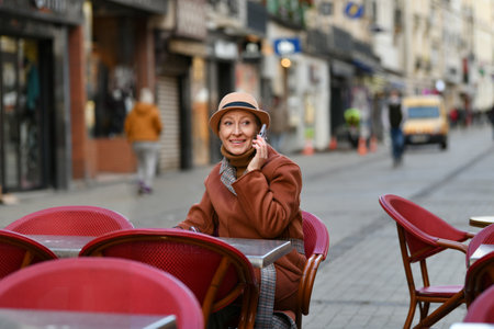 Woman in a hat talking on a mobile phoneの写真素材