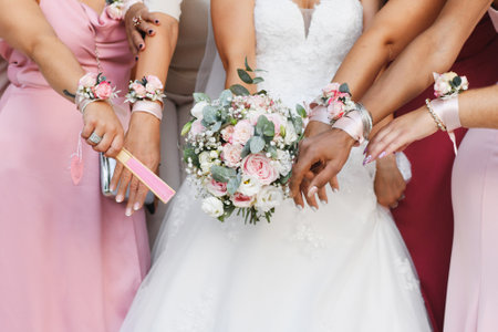 Bride with a bouquet and bridesmaids in identical dresses and braceletsの写真素材