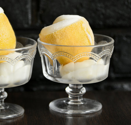 ice cream sorbet in lemon and glass on black backgroundの写真素材