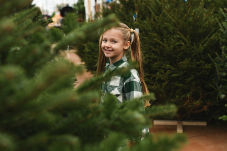 Small girl chooses a Christmas tree at the forestryの写真素材