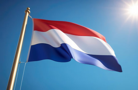 Netherlands flag on the blue sky at the sunの素材