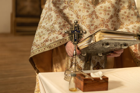 A priest in a cassock prays and reads the bible