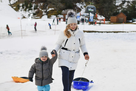 The mother with child sledding in the snowの写真素材