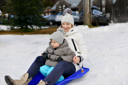 The mother with child sledding in the snowの写真素材