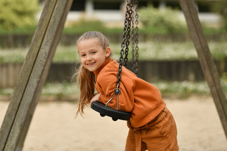 A girl riding on a swing in a parkの写真素材