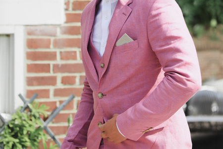 Groom in a pink suit jacket at a weddingの写真素材
