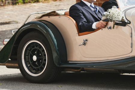 Groom in a vintage convertible retro car at a wedding. Honeymoonの写真素材