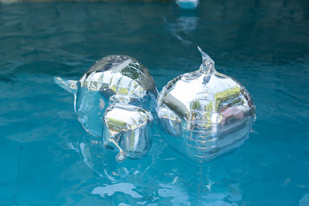 Silver balloons float in pools for a birthday party decorationsの写真素材