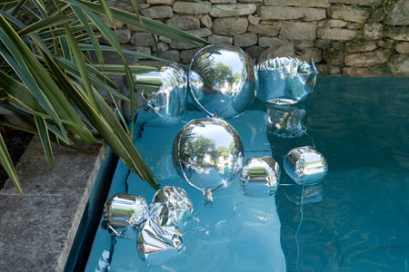 Silver balloons float in pools for a birthday party decorationsの写真素材