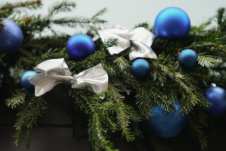 The silver bow on a christmas tree branches with blue ballsの写真素材