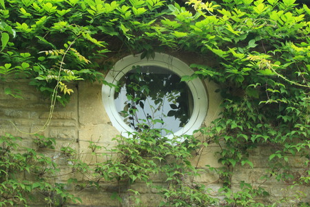 Round Window on English Cottage - Overhanging Wysteriaの写真素材