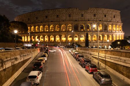 View of the night Colosseum, the road with passing cars. Rome, Italy.の写真素材