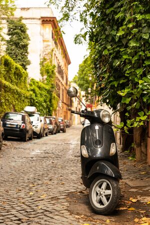 Black Vespa scooter parked on the street in Rome. Rome, Italy, May 2019.の写真素材