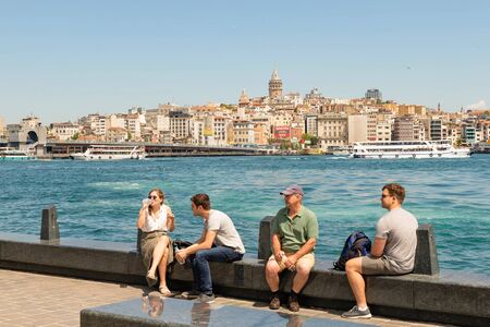 Istanbul view of the Golden horn Strait, on the waterfront people admire the view and drink water in the background is visible Galata tower and Galata bridge. Istanbul, Turkey, May 2019.のeditorial素材