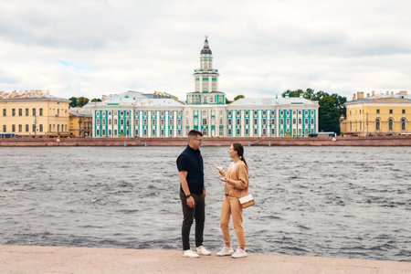 Young people stand on the river embankment in the city, talking, summer day. Russia, Saint Petersburg July 2020のeditorial素材