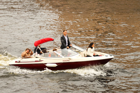 A small pleasure boat with people floating on the river. Russia, Saint Petersburg July 2020のeditorial素材