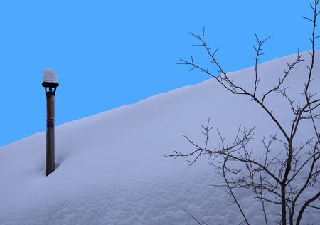 The entire roof of the house was covered with snow, and on it was visible only one pipe.の写真素材