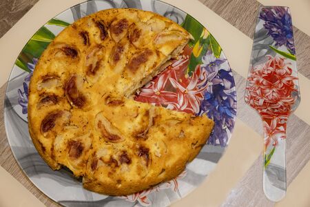 On a plate is an apple pie and a serving spatula next to it.の写真素材