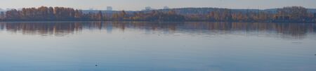 Autumn yellow-green shore on a background of blue water of the pond.の写真素材