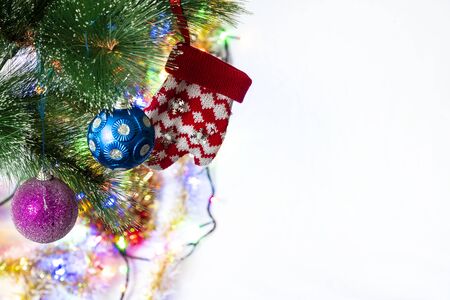 Festive New Year decorations on a Christmas tree branch, in the form of balls and a children's glove.の写真素材