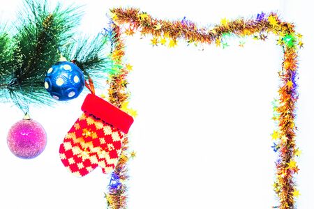 Festive New Year decorations on a Christmas tree branch, in the form of balls and a children's glove.の写真素材