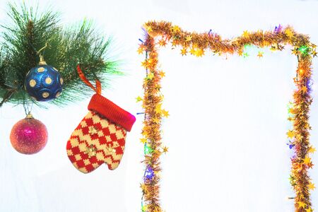 Festive New Year decorations on a Christmas tree branch, in the form of balls and a children's glove.の写真素材