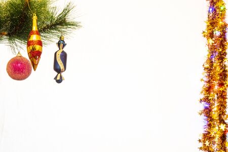 Festive New Year decorations on a Christmas tree branch, in the form of balls and a children's glove.の写真素材