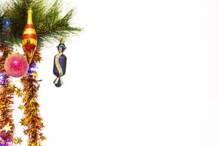 Festive New Year decorations on a Christmas tree branch, in the form of balls and a children's glove.の写真素材