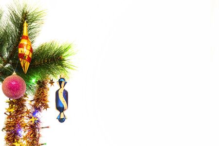 Festive New Year decorations on a Christmas tree branch, in the form of balls and a children's glove.の写真素材