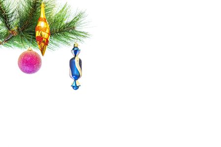 Festive New Year decorations on a Christmas tree branch, in the form of balls and a children's glove.の写真素材