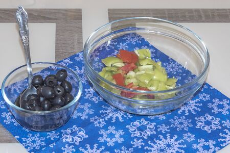 A variety of ingredients for the preparation of vegetable salad with cheese lie on the table.の写真素材