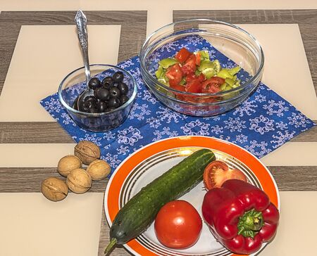 A variety of ingredients for the preparation of vegetable salad with cheese lie on the table.の写真素材
