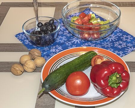A variety of ingredients for the preparation of vegetable salad with cheese lie on the table.の写真素材