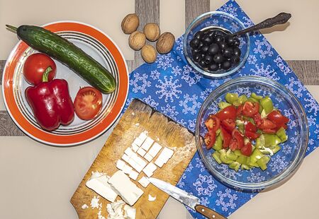 A variety of ingredients for the preparation of vegetable salad with cheese lie on the table.の写真素材