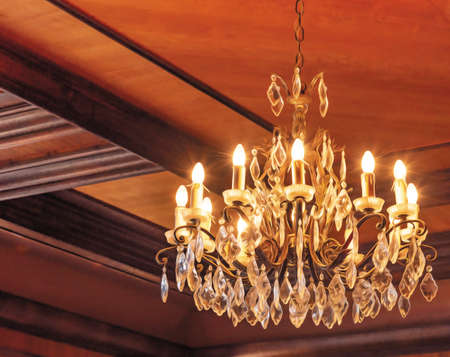 Close-up of a crystal chandelier on the ceiling made of wood.の写真素材