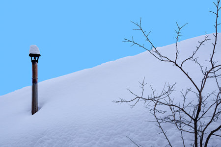 The entire roof of the house was covered with snow, and on it was visible only one pipe.の写真素材