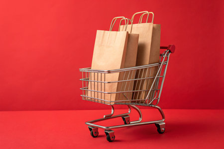 Shopping cart with purchases on red backgroundの素材