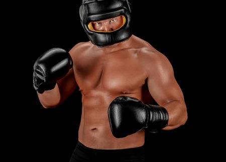 Boxer man face closed mask athletic body on black background. Studio shot.の写真素材