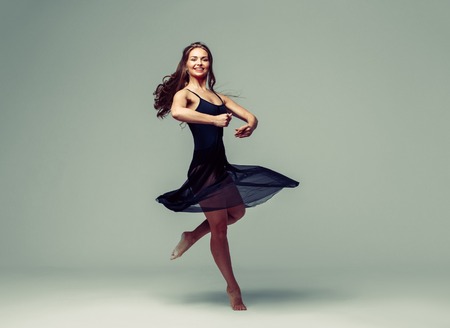Woman in dance studio beautiful. Studio shot. Gray background.の写真素材