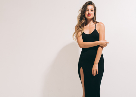 Fashion woman portrait sexy in black dress hot summer near white backgroundの写真素材