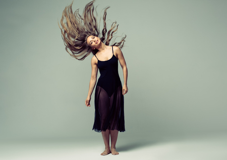Woman in dance studio beautiful. Studio shot. Gray background.の写真素材