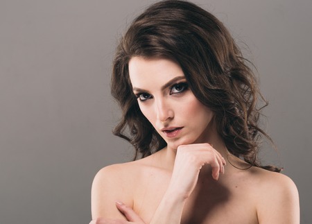 Beautiful woman face close up portrait young. Studio shot. Gray background.の写真素材