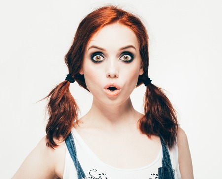 Fashion girl woman hipster portrait. The girl with red hair in denim clothes. Isolated on white. Studio shot.の写真素材