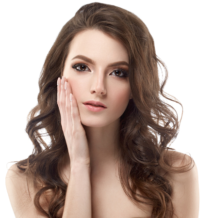 Beautiful woman face portrait with curly flying hair studio on white touching faceの写真素材