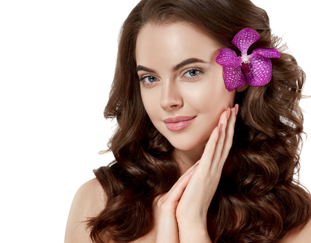 Beautiful woman face close up portrait long beautiful hair with flower young studio on whiteの写真素材