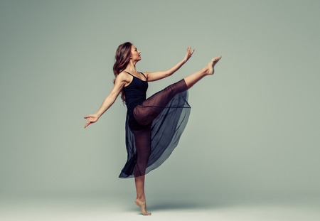 Woman in dance studio beautiful. Studio shot. Gray background.の写真素材