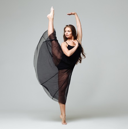 Woman in dance studio beautiful. Studio shot. Gray background.の写真素材