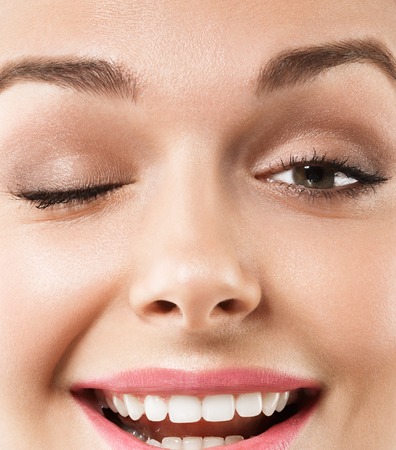 Eyes woman wink closeup. Studio shot. Close up viewの写真素材