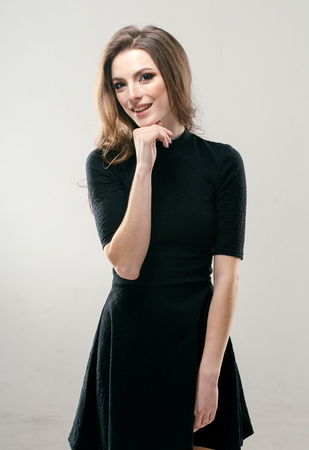 Portrait of beautiful young curly hair woman girl in black dress. Fashion photoの写真素材