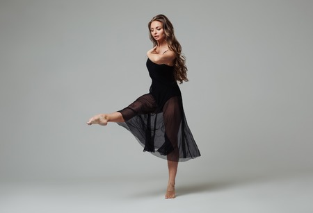 Woman in dance studio beautiful. Studio shot. Gray background.の写真素材